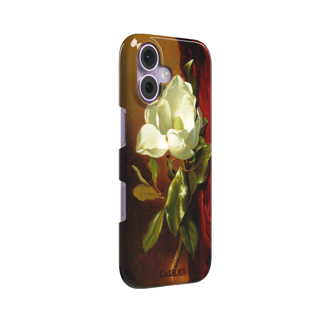 A Magnolia on Red Velvet by Martin Johnson Heade phone case showing a luminous white magnolia bloom with deep green leaves against rich red velvet drapery on a warm amber background, phone case by Caselier — snap case, left view
