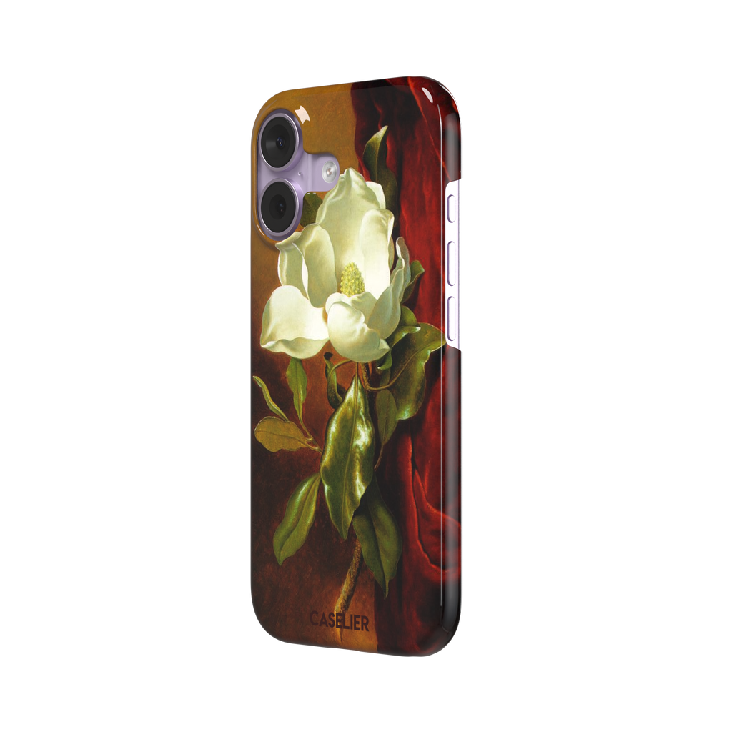 A Magnolia on Red Velvet by Martin Johnson Heade phone case showing a luminous white magnolia bloom with deep green leaves against rich red velvet drapery on a warm amber background, phone case by Caselier — snap case, right view