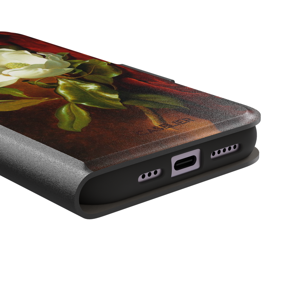 A Magnolia on Red Velvet by Martin Johnson Heade phone case showing a luminous white magnolia bloom with deep green leaves against rich red velvet drapery on a warm amber background, phone case by Caselier — wallet case, charging port detail