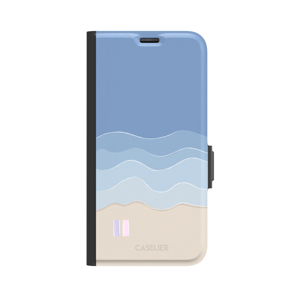 Beach phone case featuring layered blue waves graduating to a sandy beige shore with two miniature striped beach umbrellas, from the Memories of Summer collection, phone case by Caselier — wallet case, front view