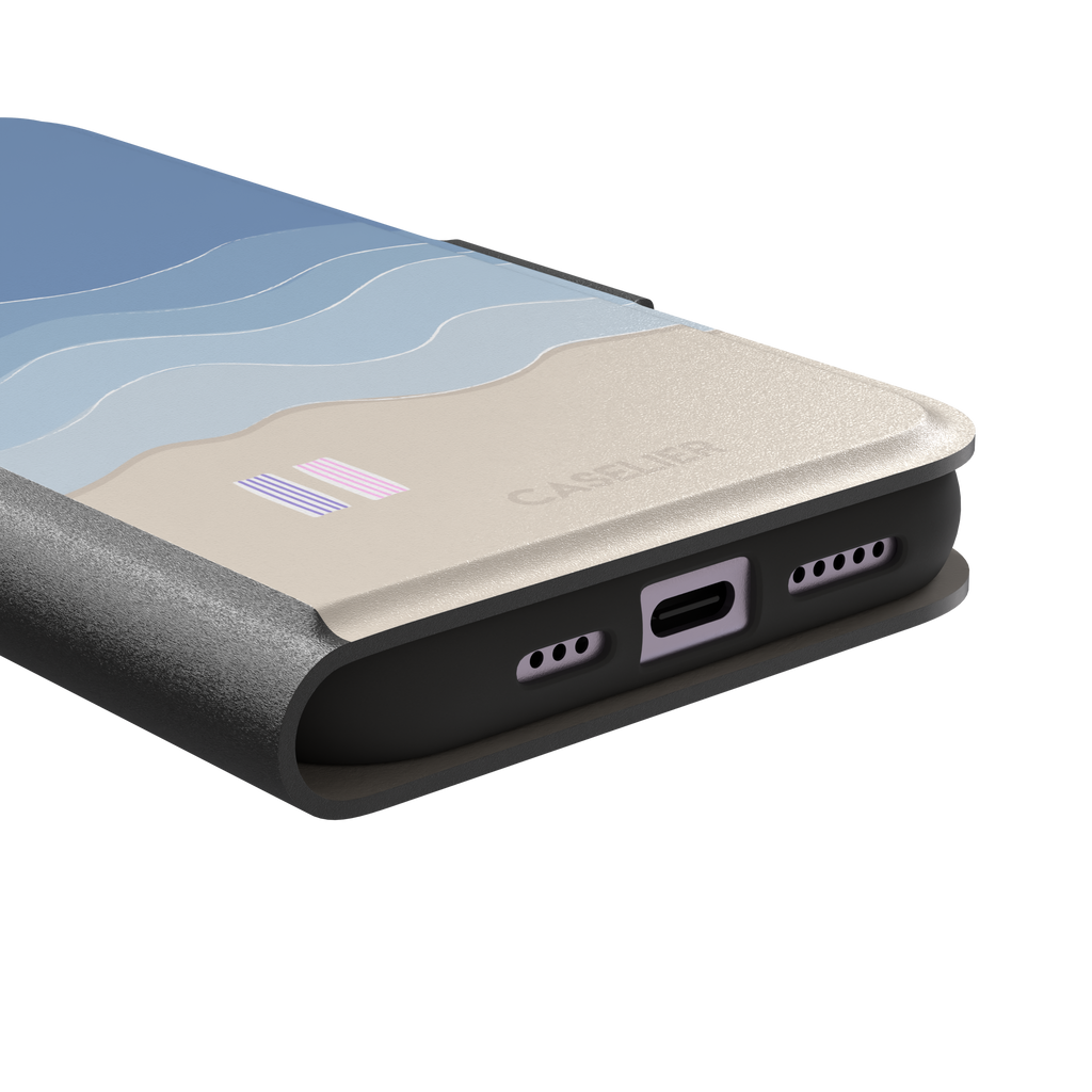Beach phone case featuring layered blue waves graduating to a sandy beige shore with two miniature striped beach umbrellas, from the Memories of Summer collection, phone case by Caselier — wallet case, charging port detail
