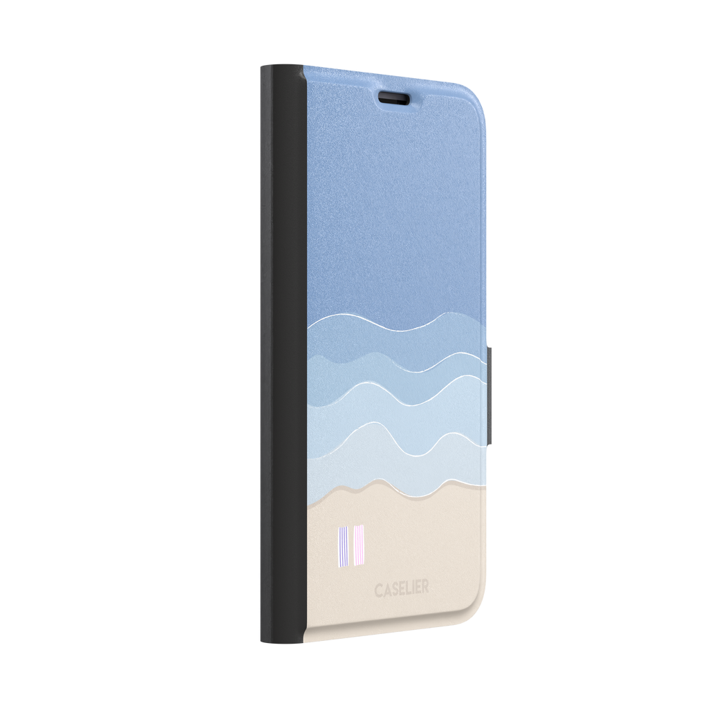 Beach phone case featuring layered blue waves graduating to a sandy beige shore with two miniature striped beach umbrellas, from the Memories of Summer collection, phone case by Caselier — wallet case, left view