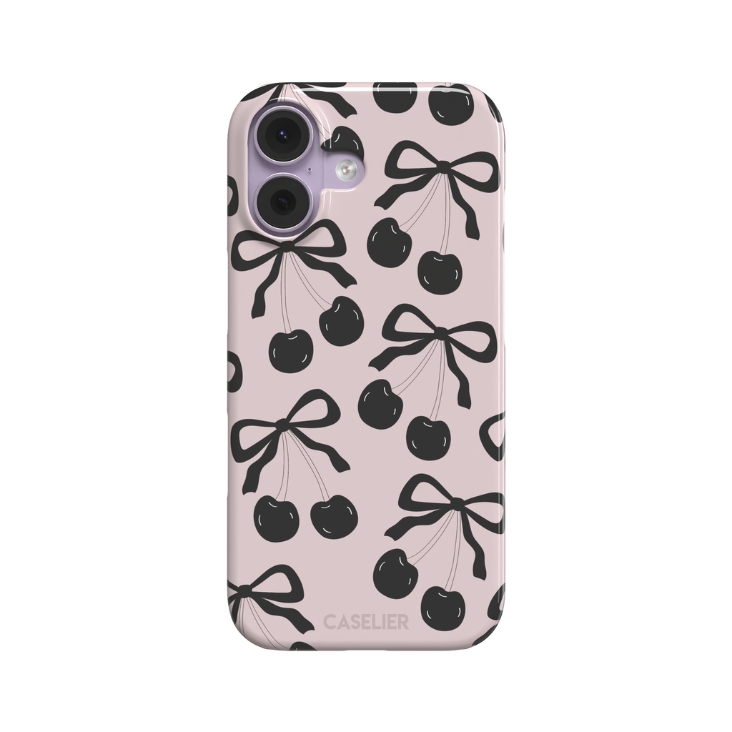 Black Cherry phone case with an all-over pattern of black cherries and ribbon bows on a blush pink background, phone case by Caselier — snap case, front view