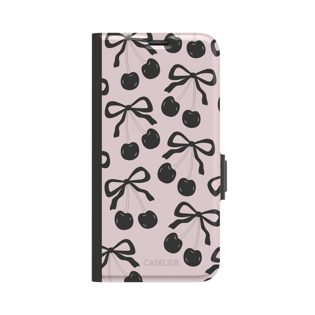 Black Cherry phone case with an all-over pattern of black cherries and ribbon bows on a blush pink background, phone case by Caselier — wallet case, front view