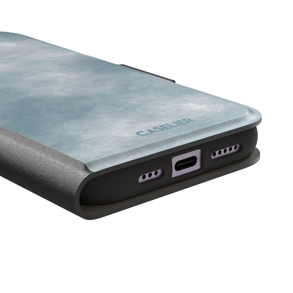 Soft powder-blue watercolor wash phone case with misty white cloud-like blends, phone case by Caselier — wallet case, charging port detail