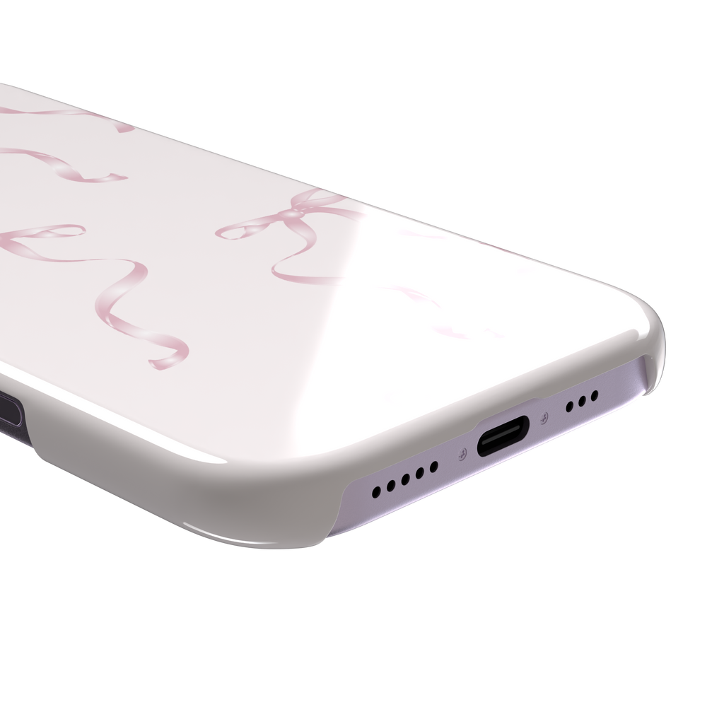 Bows phone case with scattered pink satin ribbon bows on a soft blush background, coquette style, phone case by Caselier — snap case, charging port detail