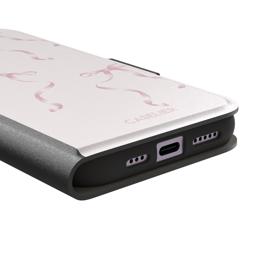 Bows phone case with scattered pink satin ribbon bows on a soft blush background, coquette style, phone case by Caselier — wallet case, charging port detail