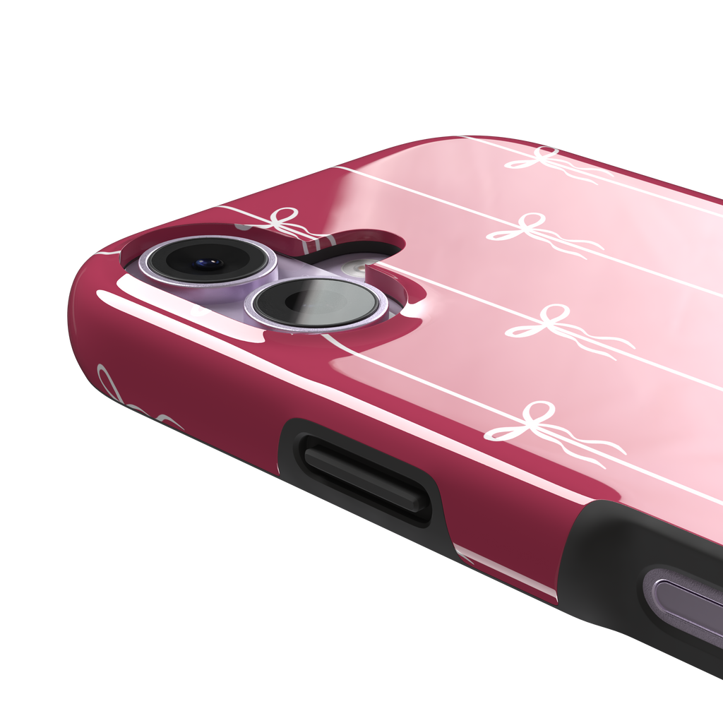 Bows on String phone case in raspberry pink with white ribbon bows tied along vertical stripes, phone case by Caselier — tough case, volume buttons detail