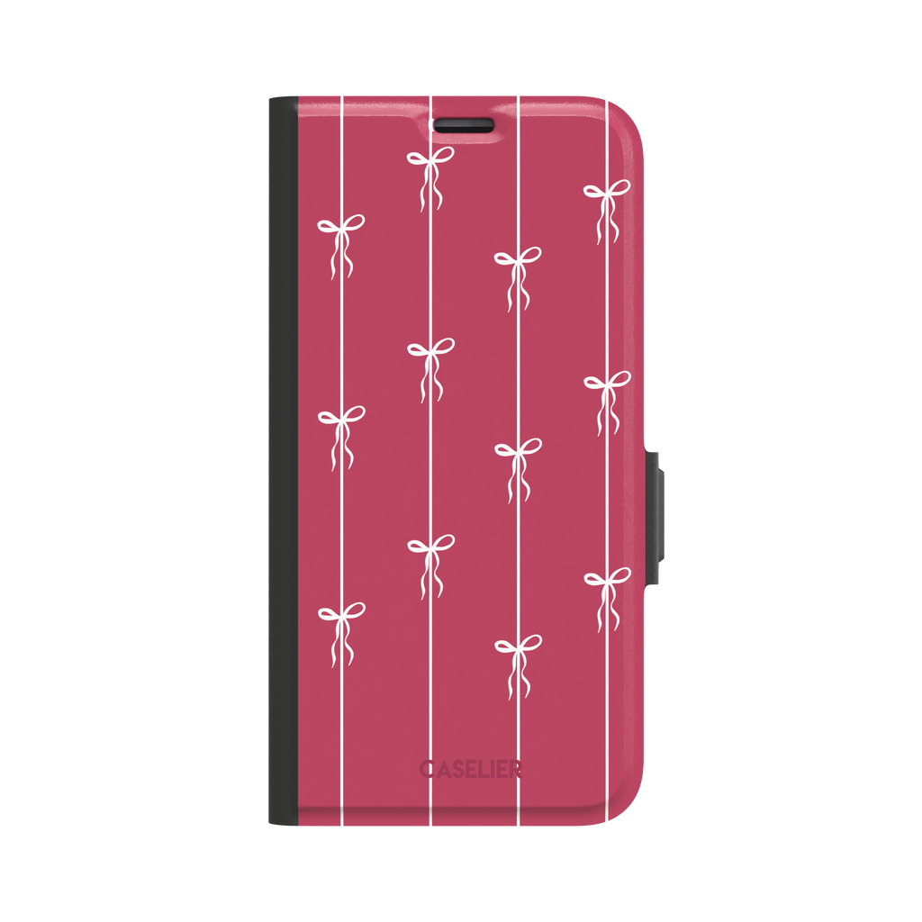 Bows on String phone case in raspberry pink with white ribbon bows tied along vertical stripes, phone case by Caselier — wallet case, front view