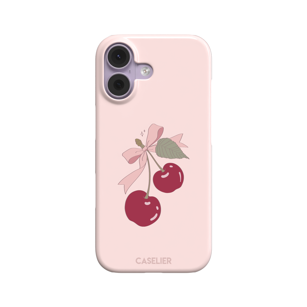 Soft pink phone case featuring two glossy red cherries tied with a pink ribbon bow and green leaf illustration in a coquette style, phone case by Caselier — snap case, front view