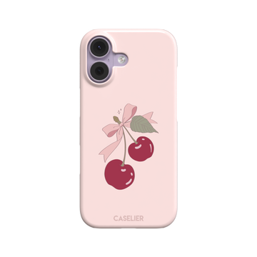 Soft pink phone case featuring two glossy red cherries tied with a pink ribbon bow and green leaf illustration in a coquette style, phone case by Caselier — snap case, front view
