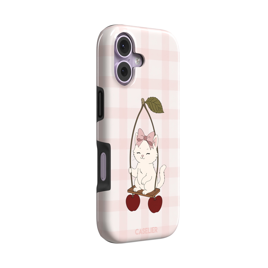 Cherry Swing phone case featuring a white cartoon kitten with a pink bow sitting on a cherry-suspended swing over a blush pink gingham background, phone case by Caselier — tough case, left view
