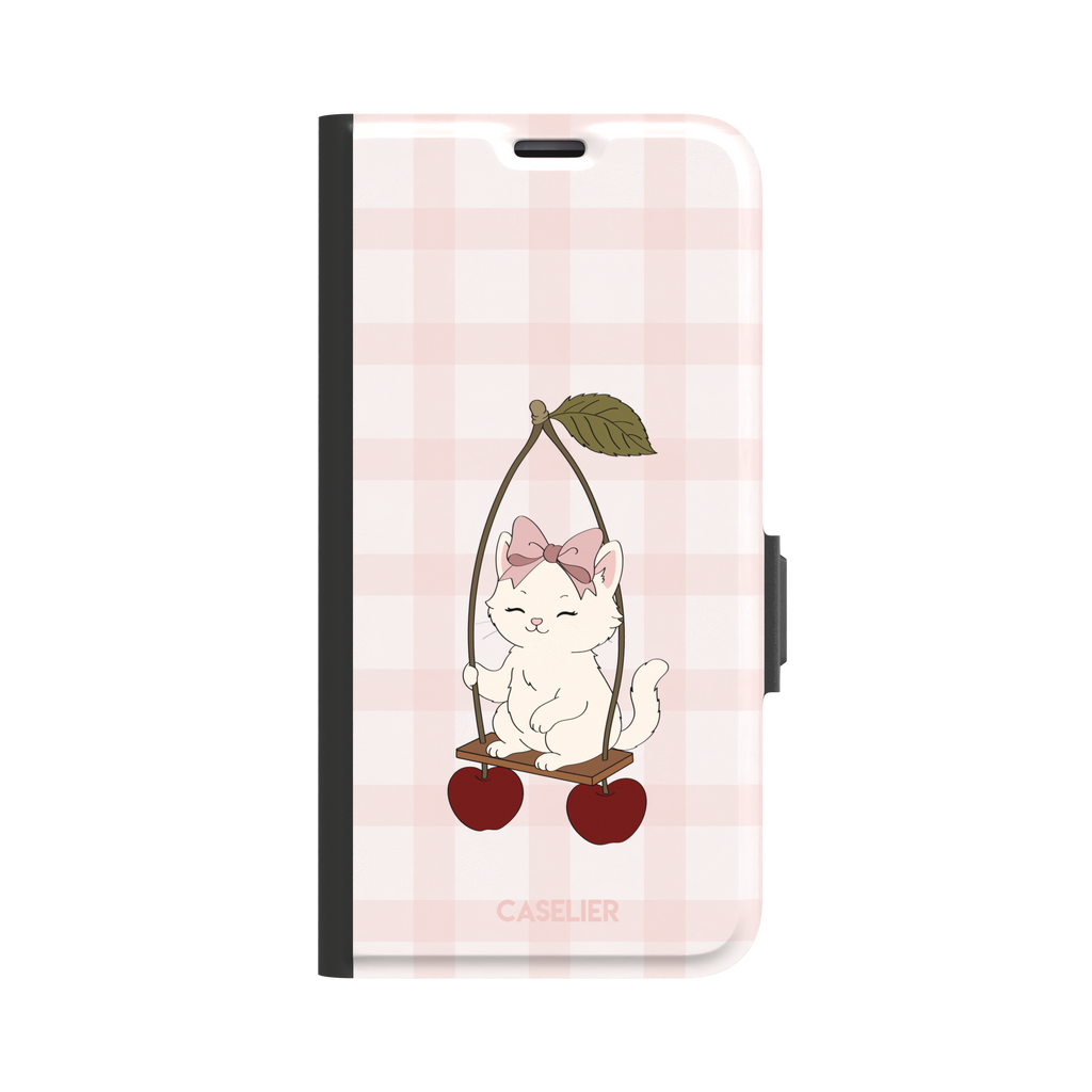 Cherry Swing phone case featuring a white cartoon kitten with a pink bow sitting on a cherry-suspended swing over a blush pink gingham background, phone case by Caselier — wallet case, front view