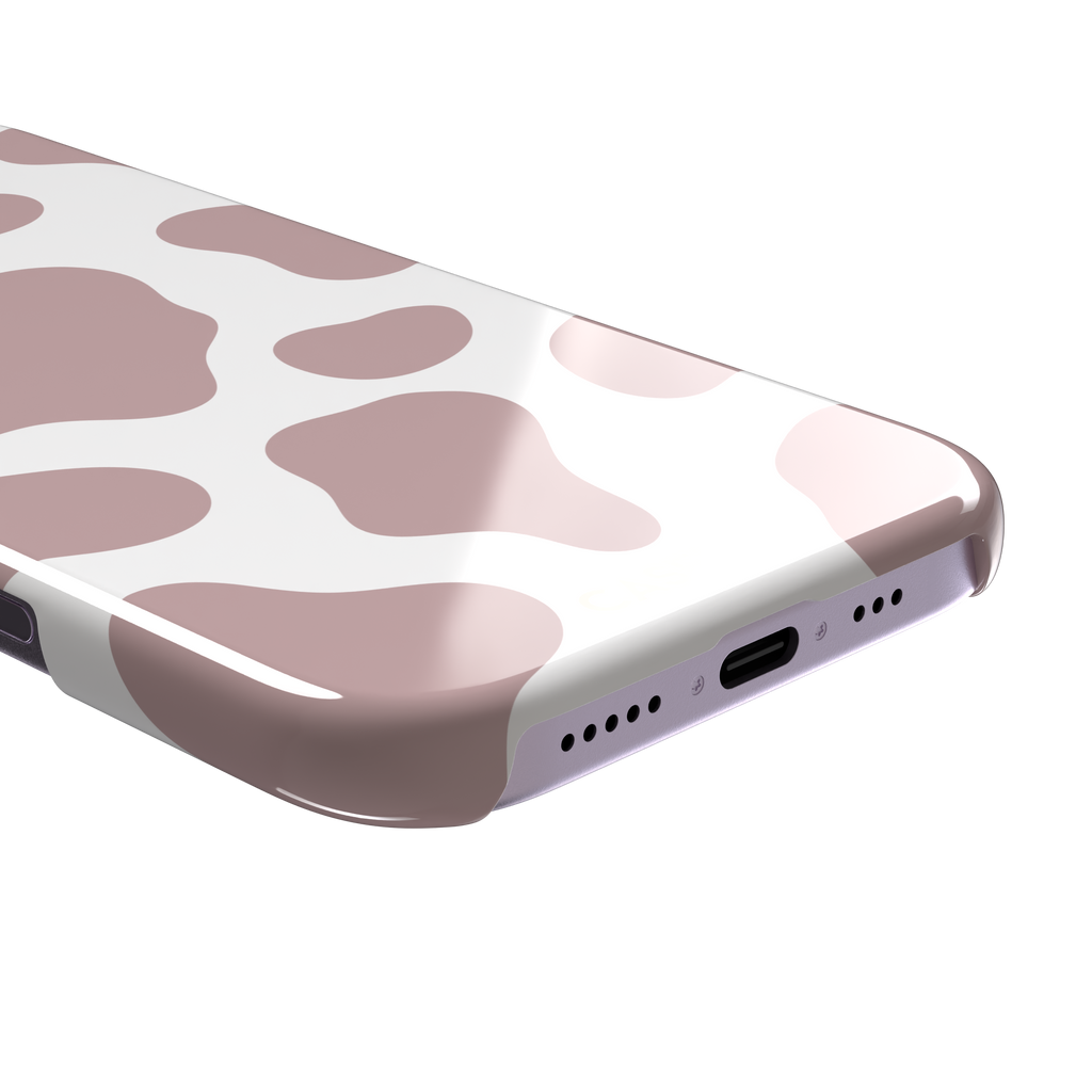 Cow print phone case in dusty rose pink and white with large soft-edged spots across the full back, phone case by Caselier — snap case, charging port detail