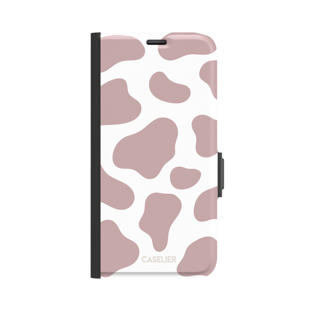Cow print phone case in dusty rose pink and white with large soft-edged spots across the full back, phone case by Caselier — wallet case, front view