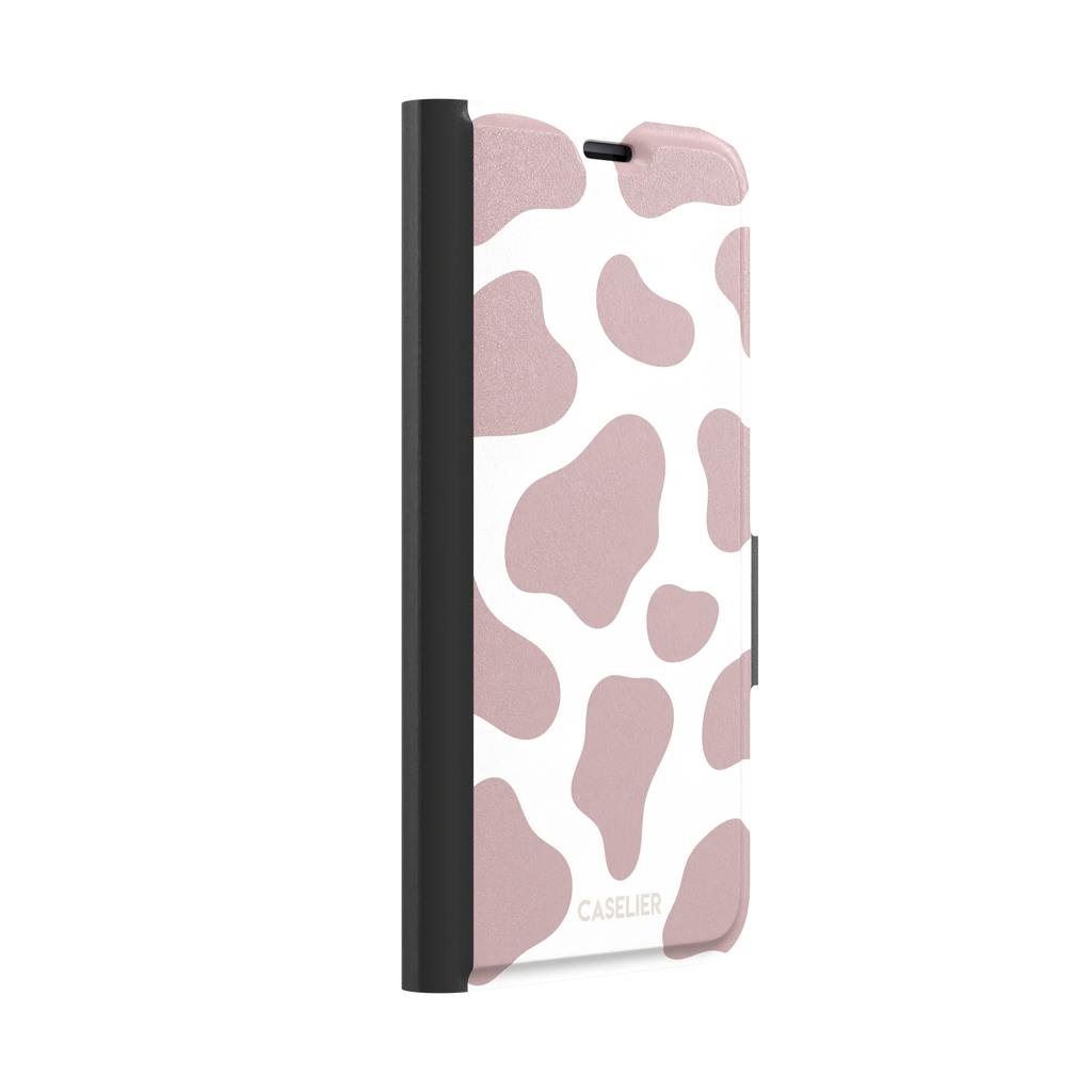 Cow print phone case in dusty rose pink and white with large soft-edged spots across the full back, phone case by Caselier — wallet case, left view