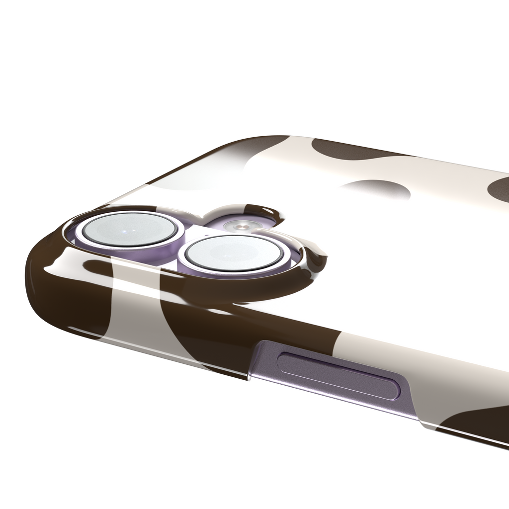 Cow print phone case in deep brown and cream with large irregular spots covering the full back, phone case by Caselier — snap case, volume buttons detail