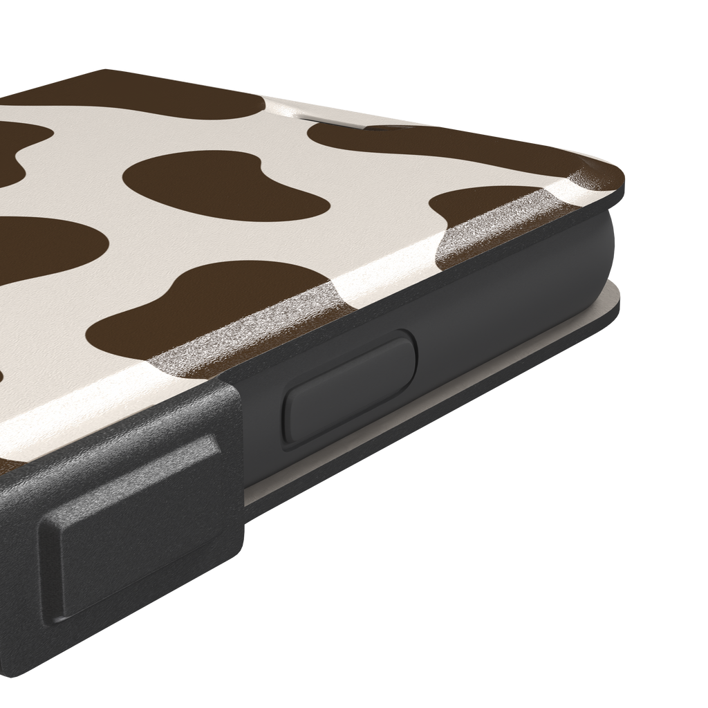 Cow print phone case in deep brown and cream with large irregular spots covering the full back, phone case by Caselier — wallet case, volume buttons detail