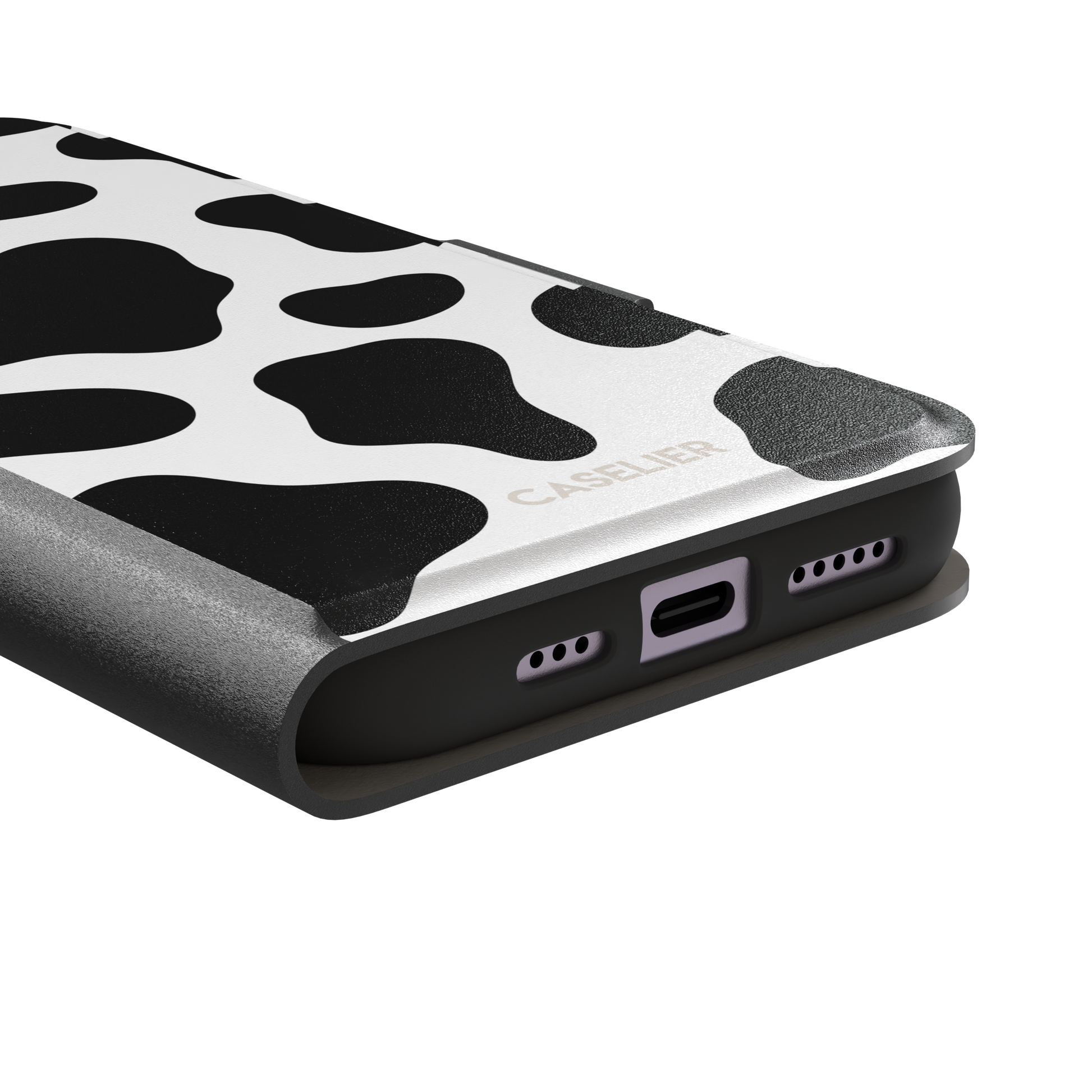 Cow print phone case in black and white with bold oversized spots on a clean white background, phone case by Caselier — wallet case, charging port detail
