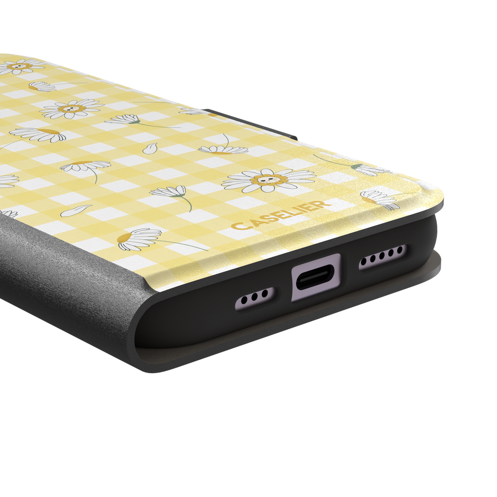 Daisies phone case variant showing white daisy flowers with small smiley faces at their centres on a yellow gingham background, phone case by Caselier — wallet case, charging port detail | Caselier