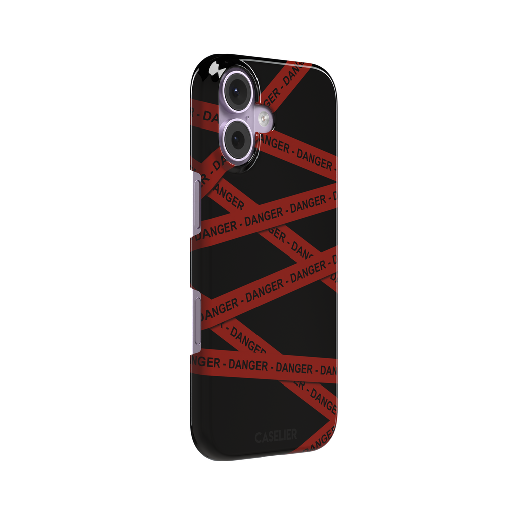Black phone case with criss-crossing red danger tape strips printed diagonally across the back, featuring bold repeated DANGER text in black lettering — snap case, left view