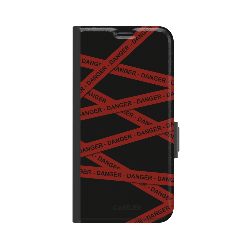 Black phone case with criss-crossing red danger tape strips printed diagonally across the back, featuring bold repeated DANGER text in black lettering — wallet case, front view