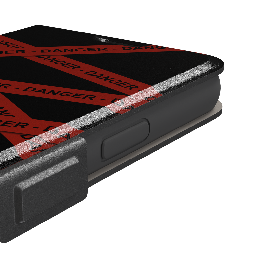 Black phone case with criss-crossing red danger tape strips printed diagonally across the back, featuring bold repeated DANGER text in black lettering — wallet case, volume buttons detail