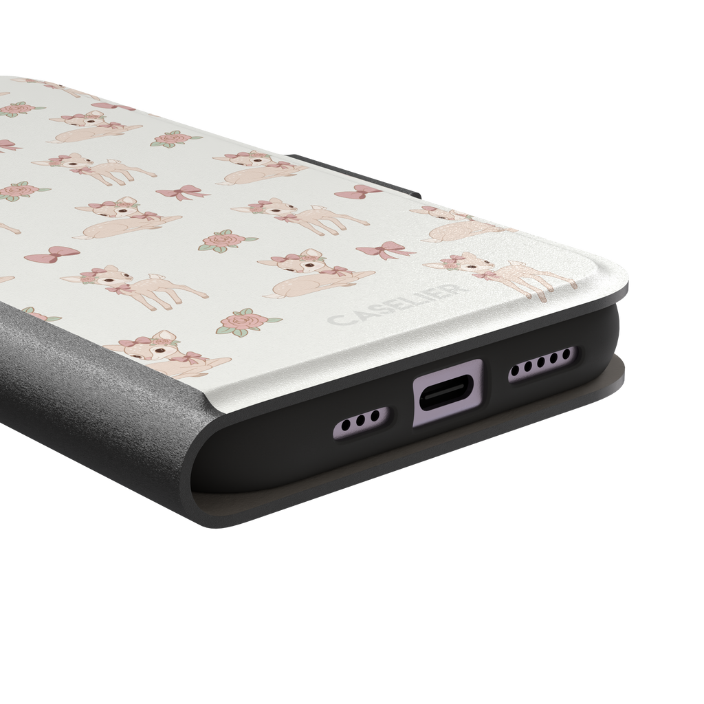 White phone case featuring a repeat pattern of illustrated fawns with pink bows and roses in a soft coquette style, phone case by Caselier — wallet case, charging port detail