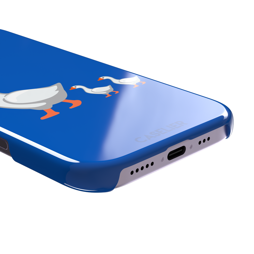 Royal blue phone case with a cartoon mother goose and two goslings walking in a line, emoji-style illustration with white birds and orange beaks and feet, phone case by Caselier — snap case, charging port detail