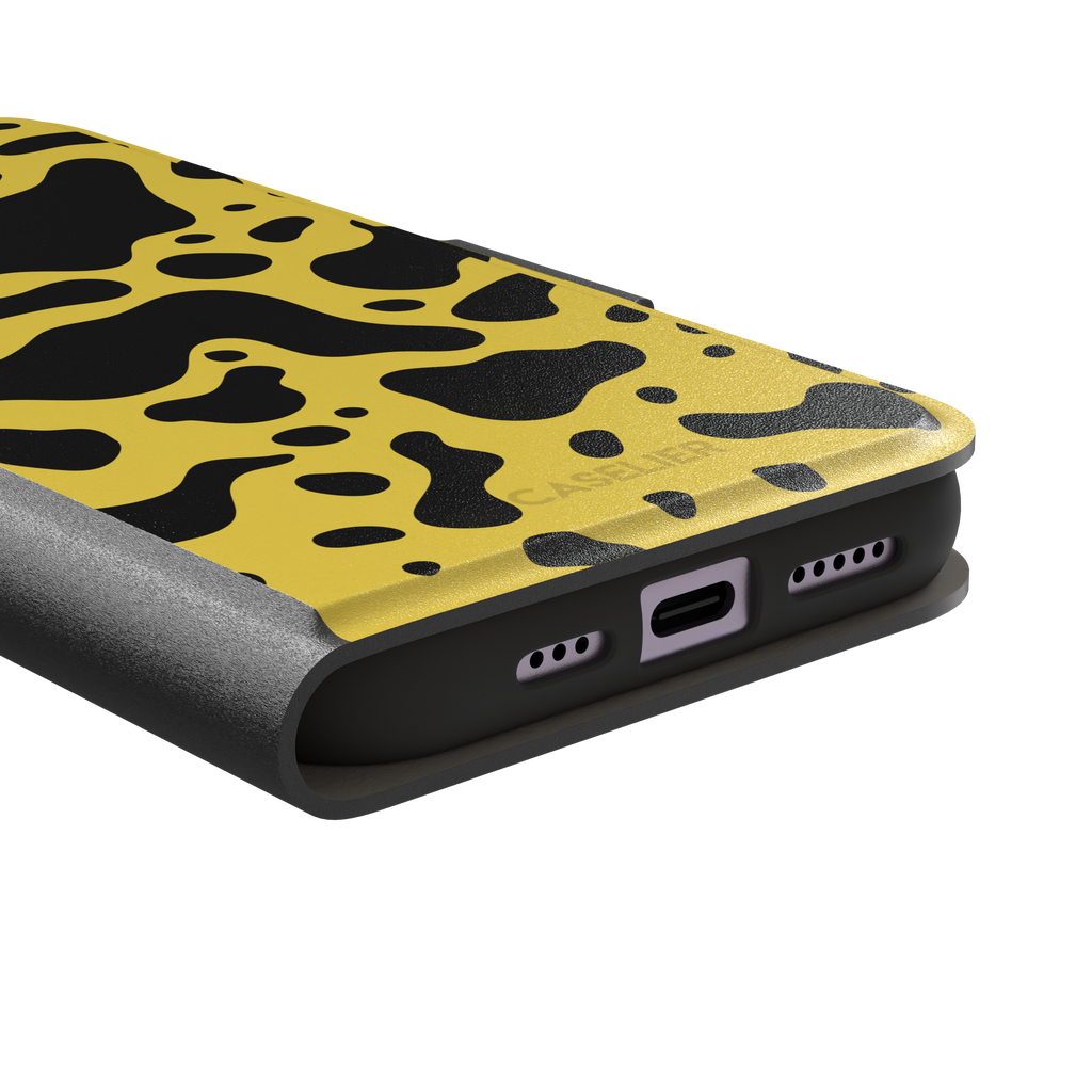 Frog phone case color variant in mustard yellow with large flowing black animal print patches, phone case by Caselier — wallet case, charging port detail