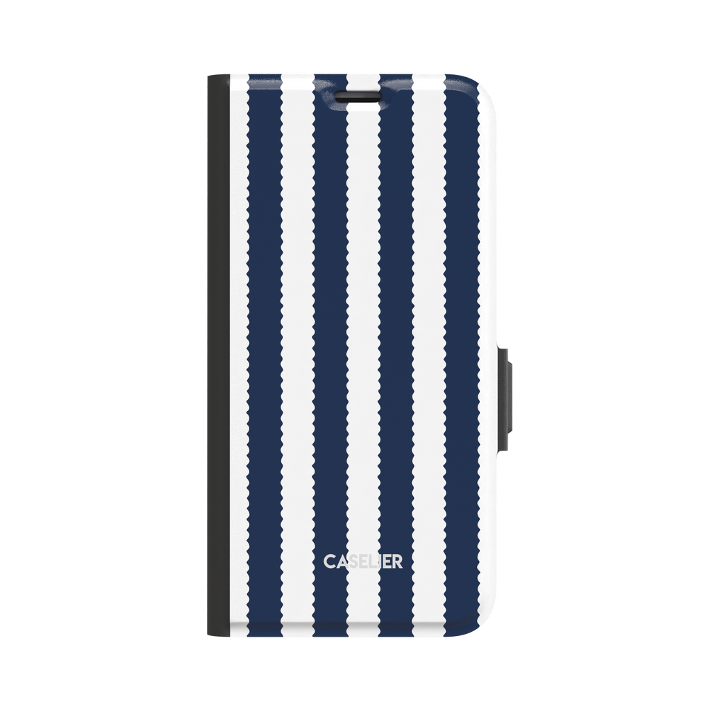 Jagged Stripes folio wallet case in navy blue and white, broad vertical stripes with wavy zigzag edges, closed folio style with black spine and side clasp, front-facing view on white background, phone case by Caselier - wallet case, front view | Caselier