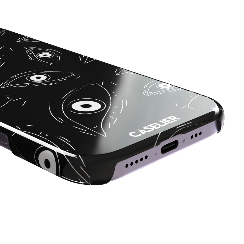 Paranoia phone case in black with all-over white hand-drawn staring eyes and sharp angular lashes, phone case by Caselier — snap case, charging port detail