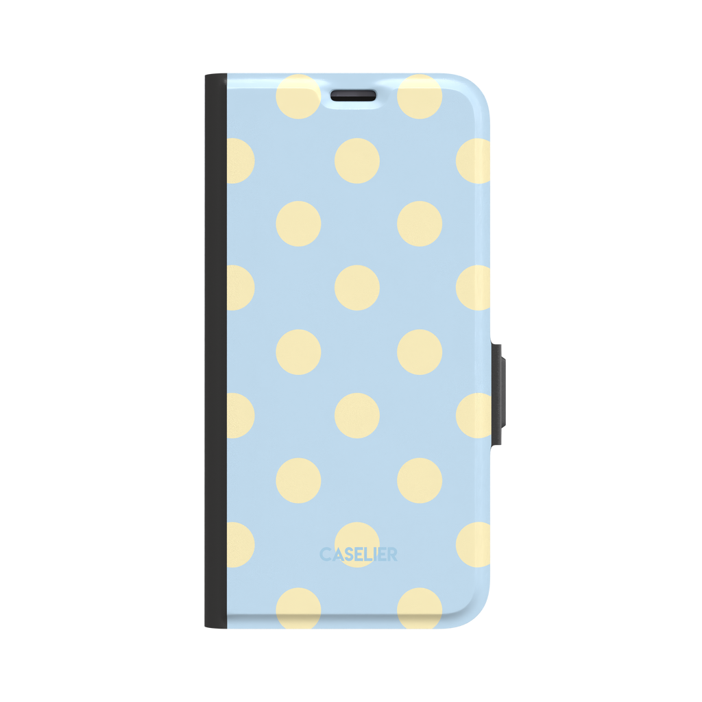 Polka Spots folio wallet case in baby blue with cream-yellow polka dots, black spine and clasp, front-facing product shot on white background, phone case by Caselier - wallet case, front view | Caselier