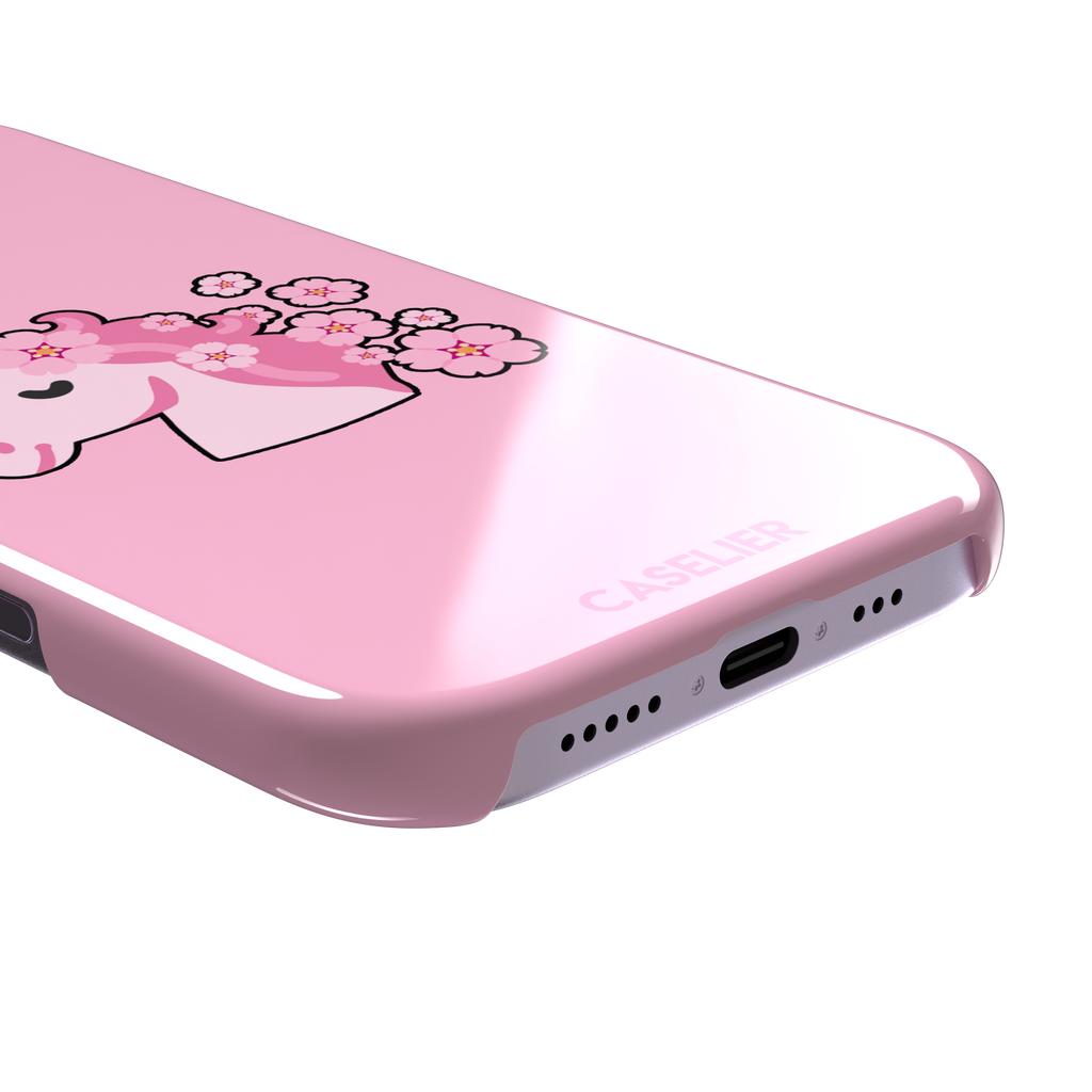Pink phone case featuring a cute cartoon unicorn with a striped horn and a cherry blossom-filled mane on a bubblegum pink background, phone case by Caselier — snap case, charging port detail