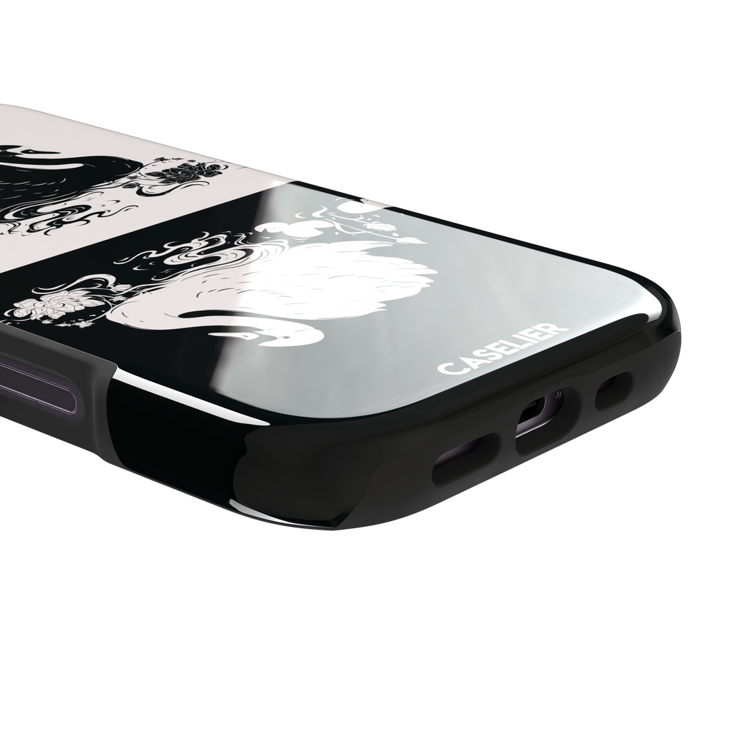 Reflection phone case in inverted colorway with a black swan on a cream upper half and a white swan on a deep black lower half, with matching lotus and water motifs — tough case, charging port detail
