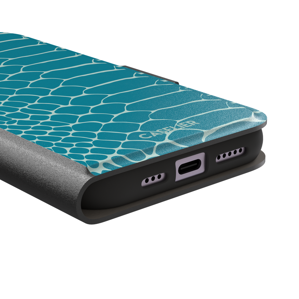 Teal and white snakeskin print phone case with bold reptile scale pattern covering the full back, phone case by Caselier — wallet case, charging port detail
