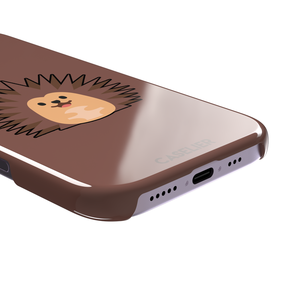 Spikey phone case with a smiling cartoon hedgehog in brown and peach tones on a warm mauve-brown background, by Caselier — snap case, charging port detail