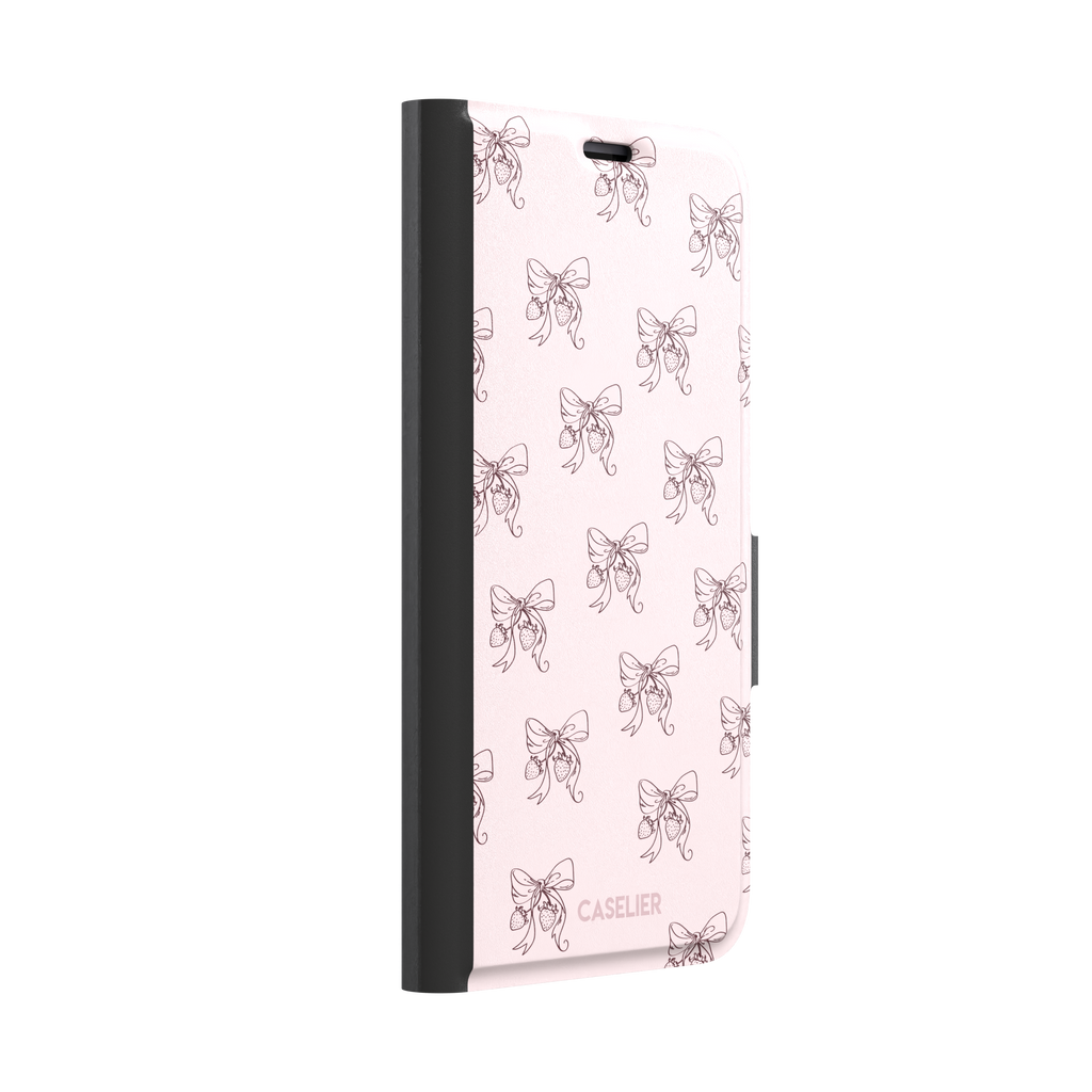 Strawberry Bows phone case in blush pink with an all-over pattern of line-drawn ribbon bows and hanging strawberries, phone case by Caselier — wallet case, left view
