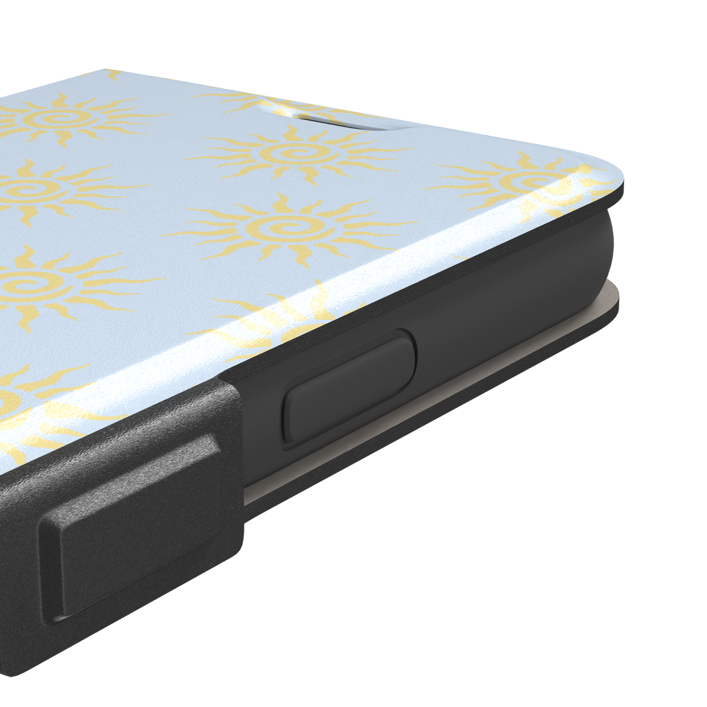 Sunkissed phone case color variant with golden yellow tribal spiral suns on a soft powder blue background, phone case by Caselier — wallet case, volume buttons detail