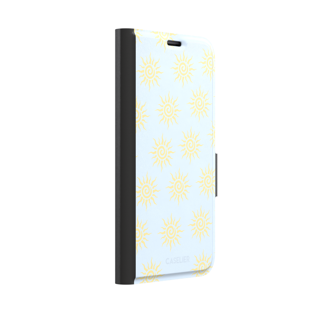 Sunkissed phone case color variant with golden yellow tribal spiral suns on a soft powder blue background, phone case by Caselier — wallet case, left view