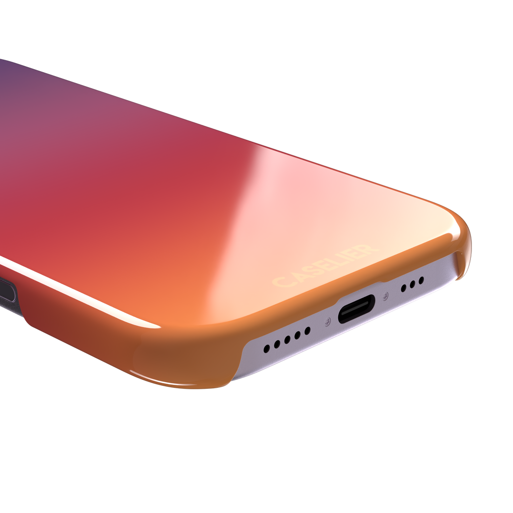 Sunrise phone case with a smooth gradient from deep purple through coral red to warm orange, part of the Memories of Summer collection, phone case by Caselier — snap case, charging port detail
