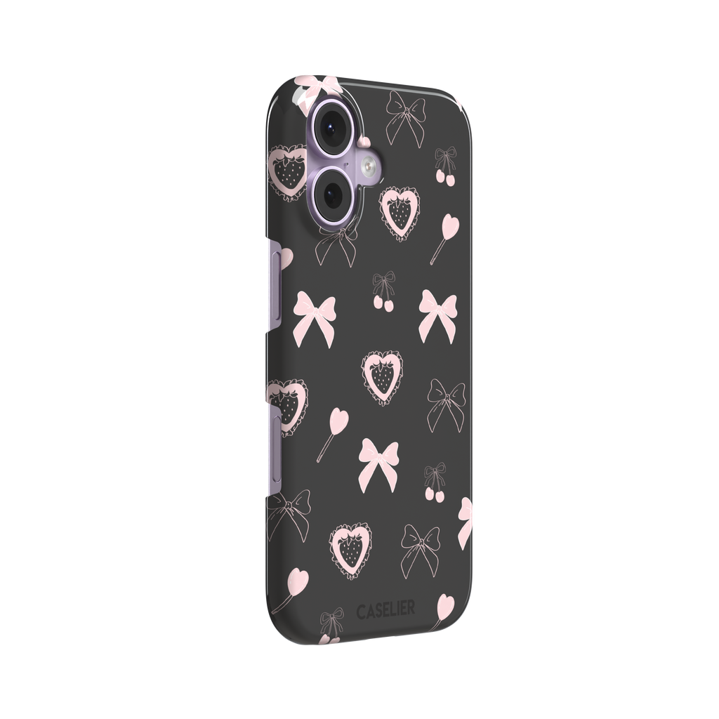 Sweetness Overload phone case in dark charcoal grey with pink bows, cherries, heart lollipops and frilled strawberry heart illustrations — snap case, left view