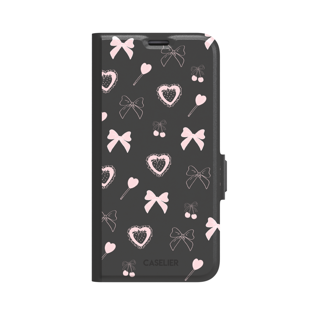 Sweetness Overload phone case in dark charcoal grey with pink bows, cherries, heart lollipops and frilled strawberry heart illustrations — wallet case, front view