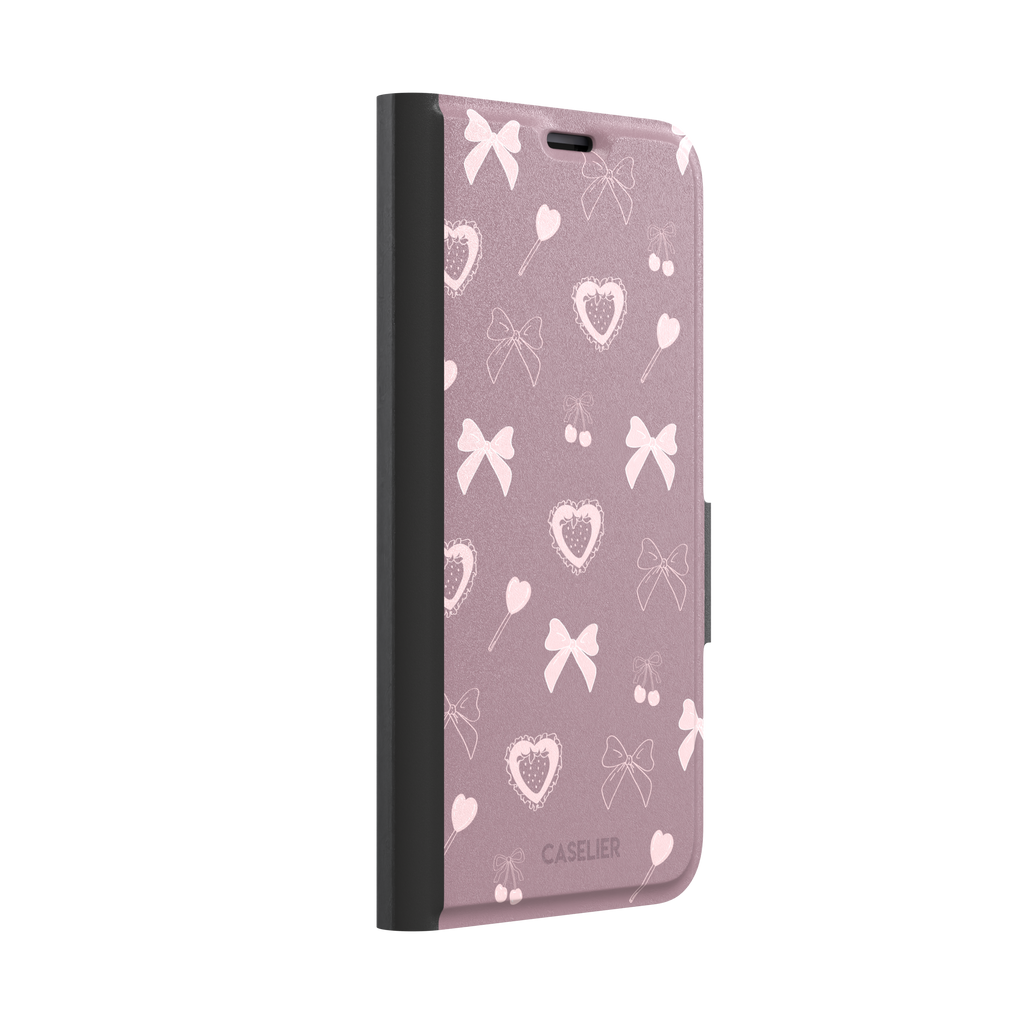 Sweetness Overload phone case in dusty pink with soft pink bows, cherries, heart lollipops and frilled strawberry heart illustrations — wallet case, left view