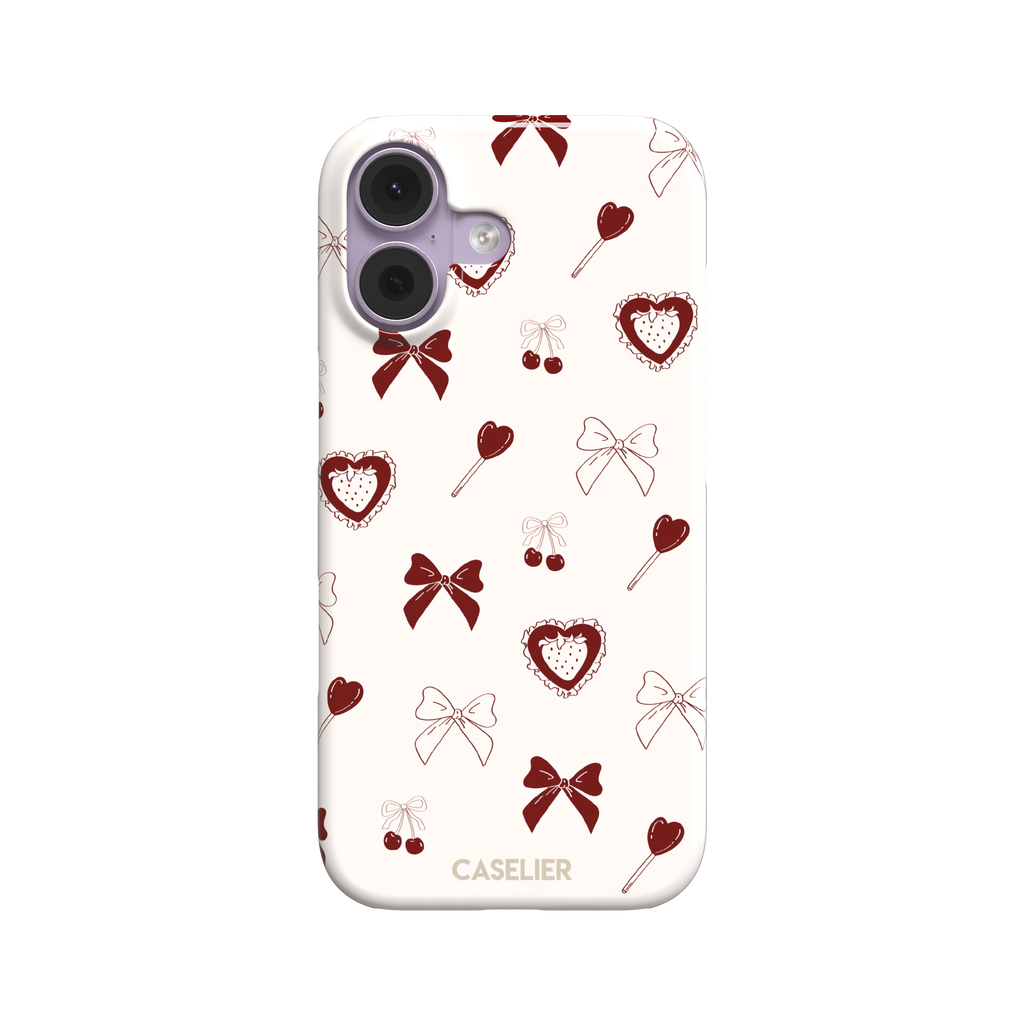 Sweetness Overload phone case in cream white with deep red bows, cherries, heart lollipops and frilled strawberry heart illustrations — snap case, front view