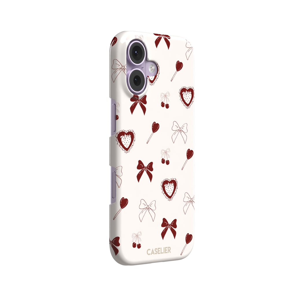 Sweetness Overload phone case in cream white with deep red bows, cherries, heart lollipops and frilled strawberry heart illustrations — snap case, left view