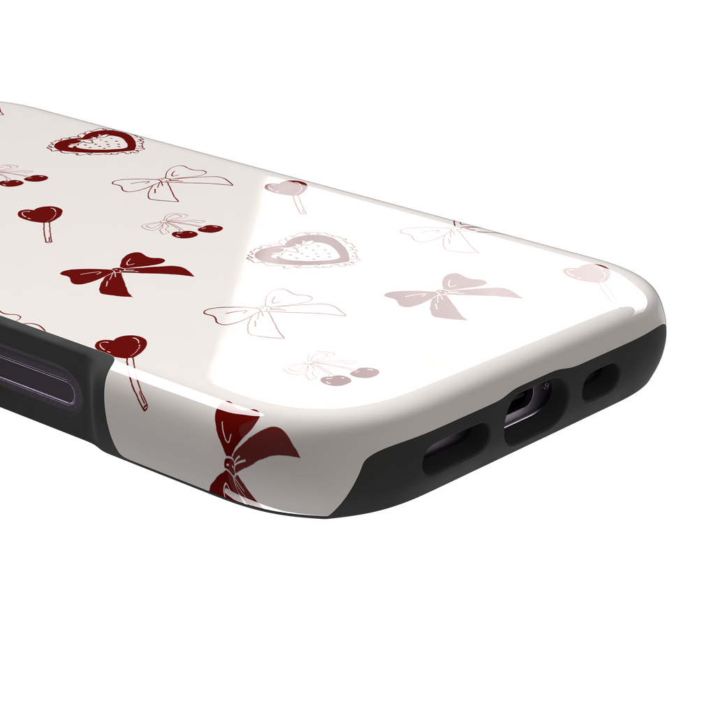 Sweetness Overload phone case in cream white with deep red bows, cherries, heart lollipops and frilled strawberry heart illustrations — tough case, charging port detail