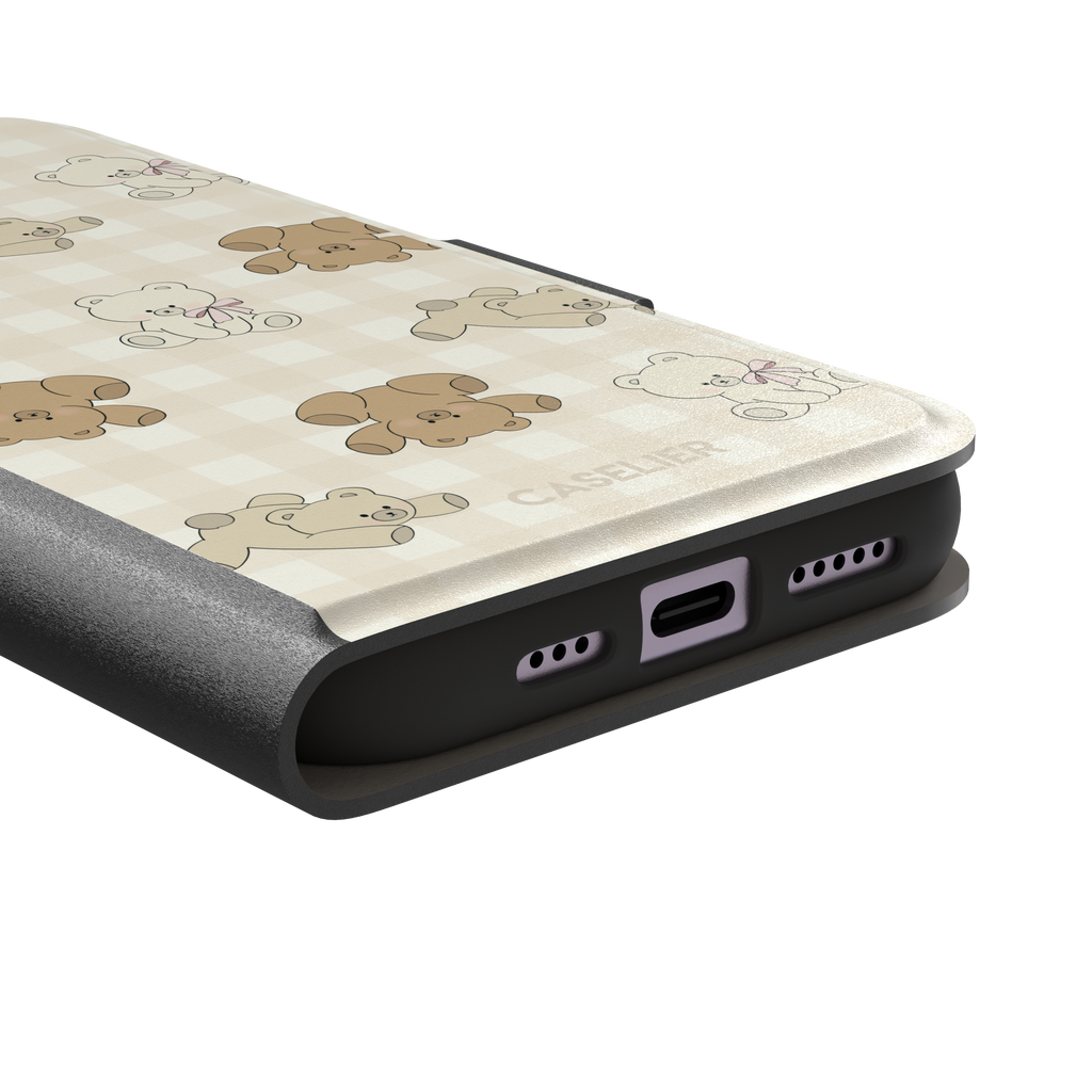 Teddybears phone case in warm cream with illustrated beige and ivory teddy bears scattered over a gingham grid pattern, some bears wearing soft pink bows — wallet case, charging port detail