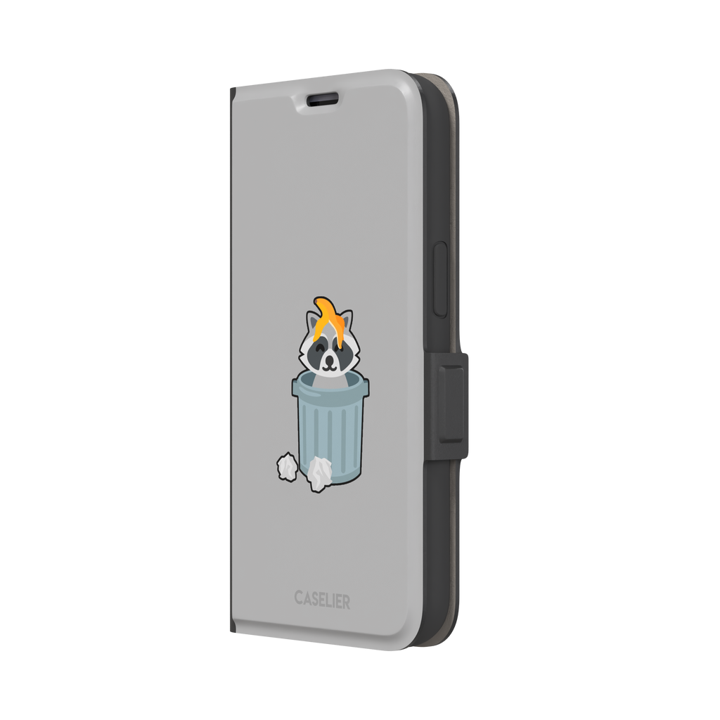 Grey phone case featuring a cute cartoon raccoon sitting inside a metal trash can with an orange food scrap on its head and crumpled paper on the ground, phone case by Caselier — wallet case, right view